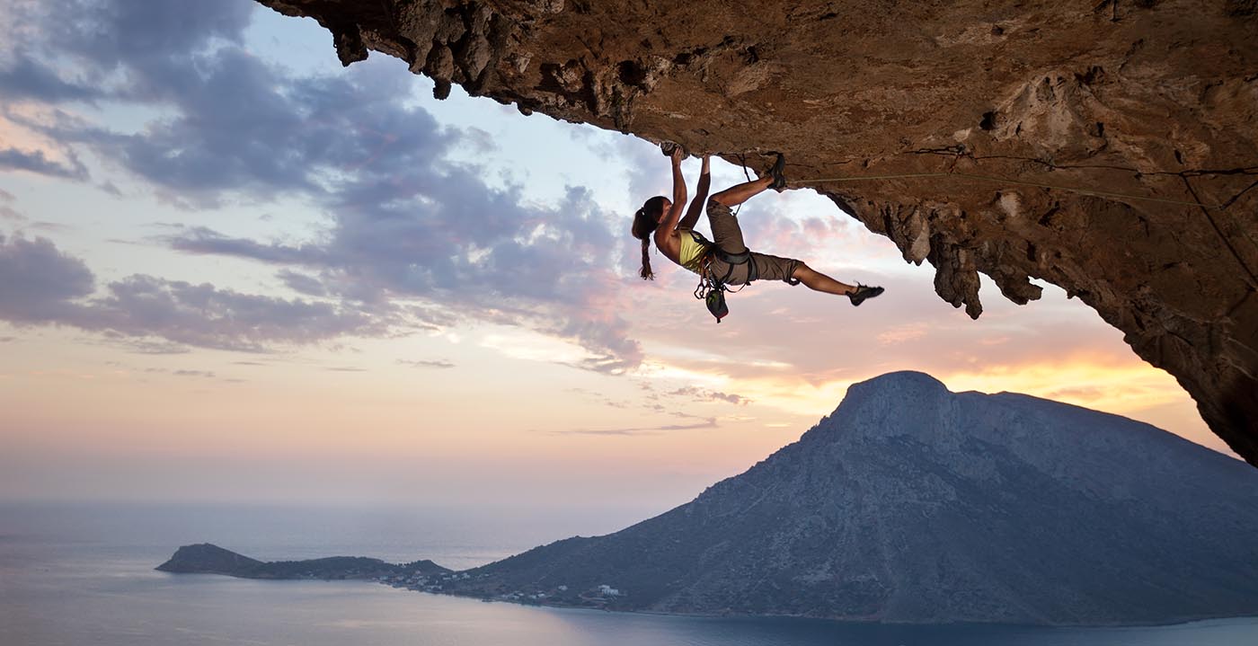Woman rock climbing on a large rock overhang